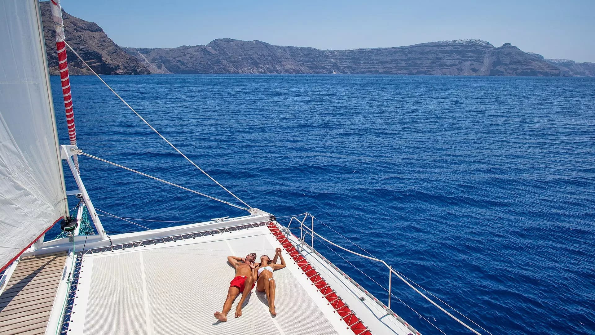 Casal deitado em passeio de barco em uma lua de mel em Santorini, Grécia