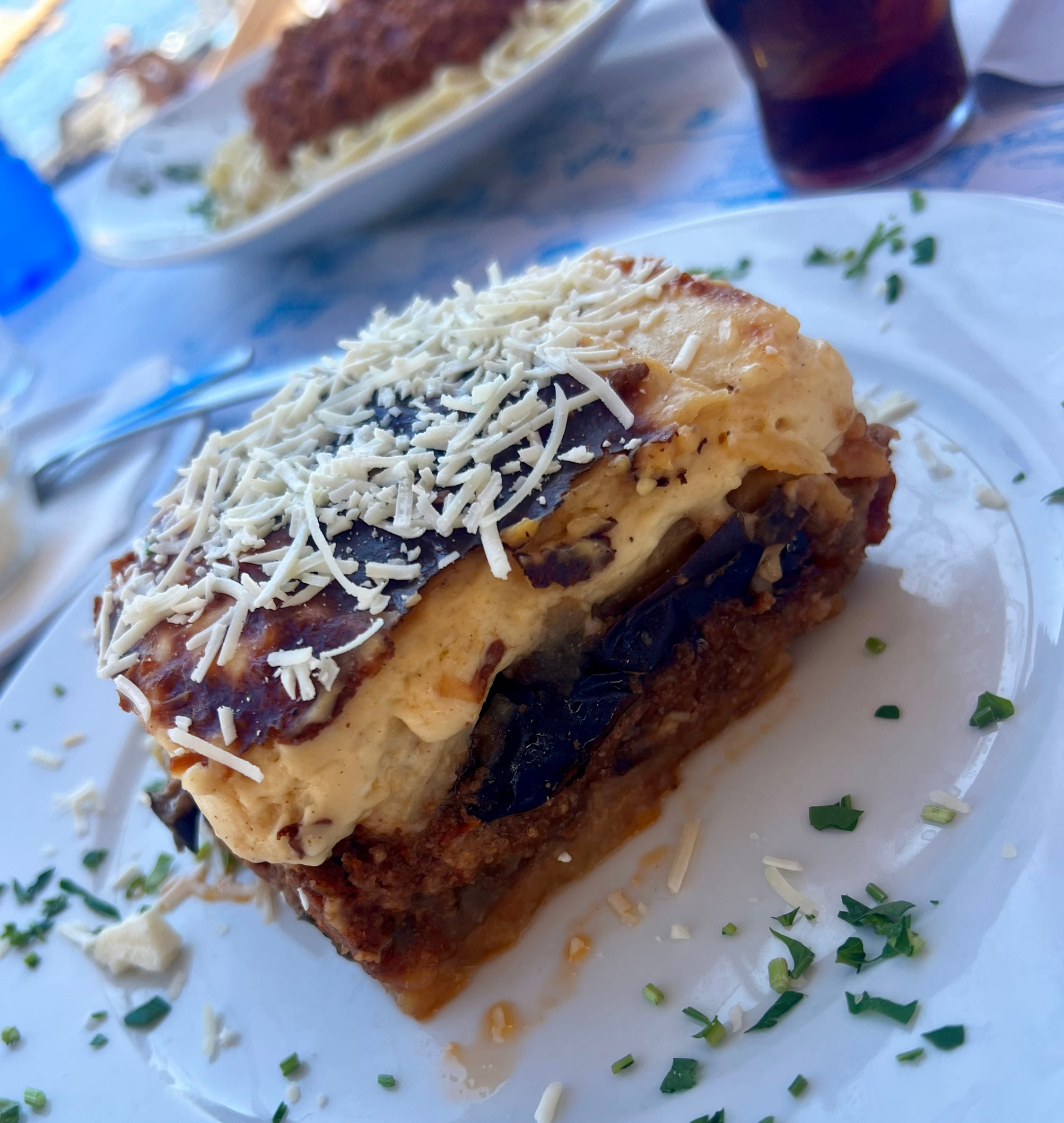 Moussaka tradicional da culinária grega, preparada com berinjela, carne e molho cremoso gratinado, um dos pratos mais famosos e autênticos de Santorini.