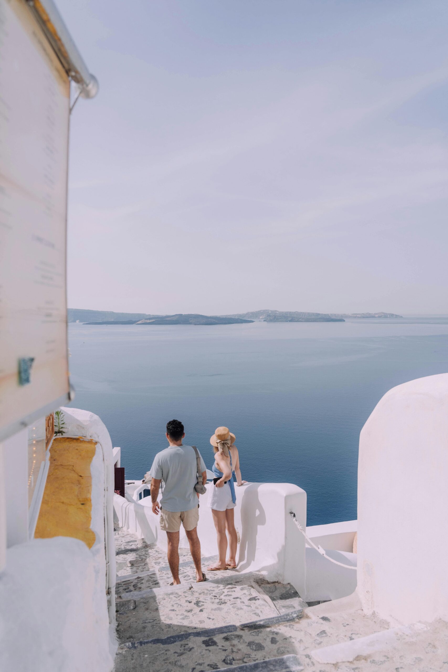 Casal descendo escadas em santorini grecia