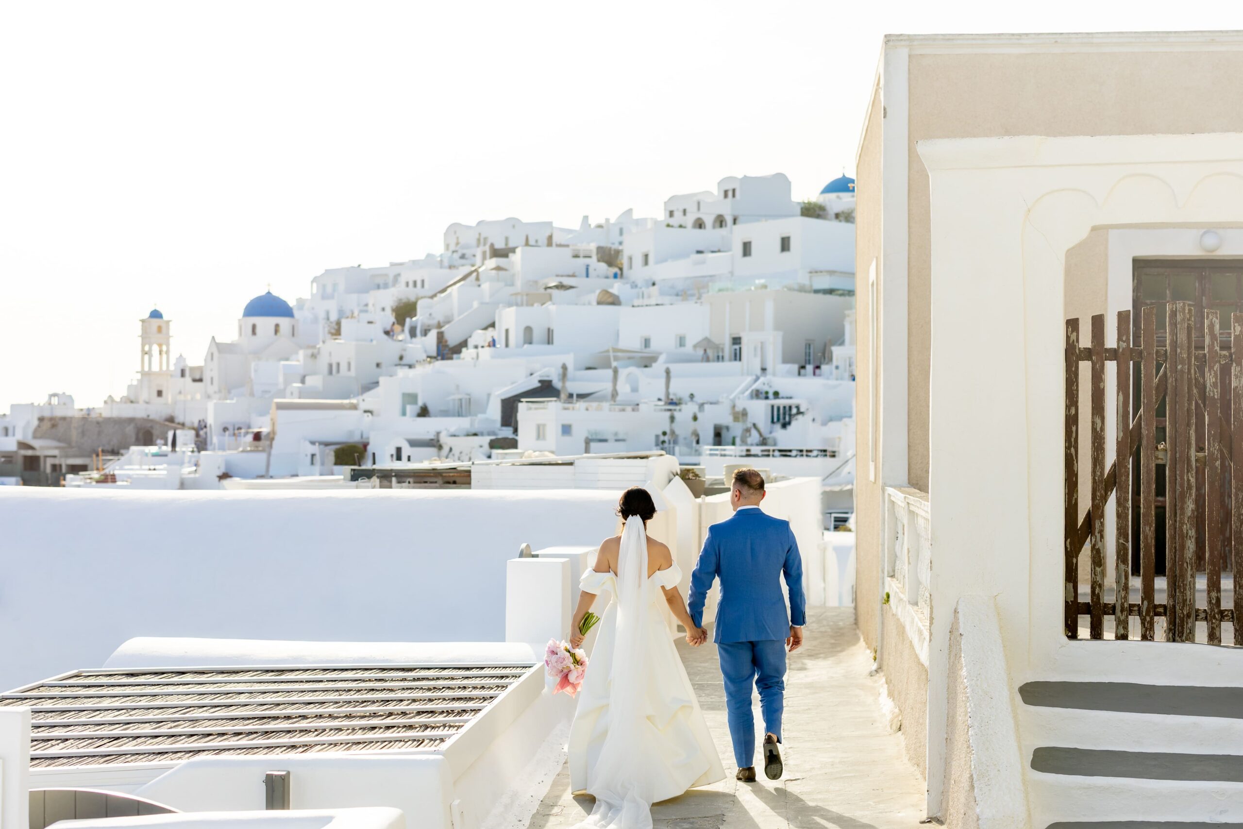 noivos caminhando em santorini grecia