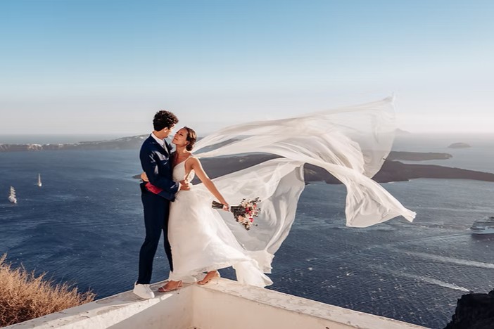Noivos em Santorini, Grecia. Noiva com veu ao vento.