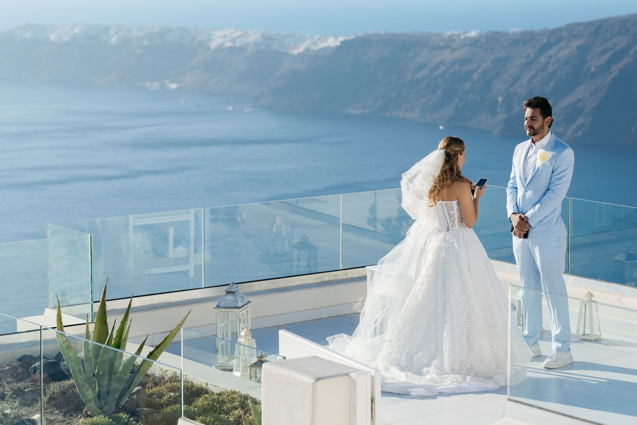 Noivos na terraça do casamento, com vista para caldeira, Santorini, Grecia