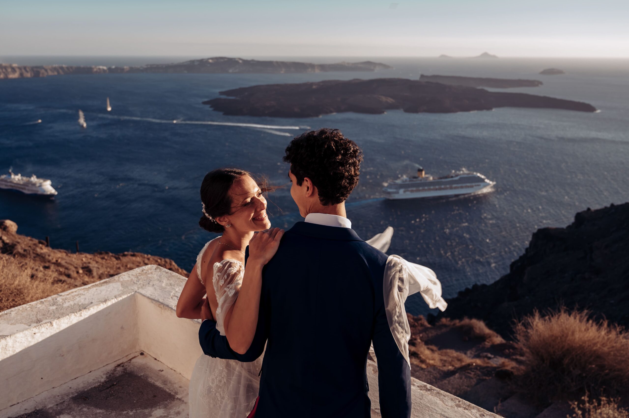 Casais se olhando em por do sol na caldeira de Santorini, Grecia